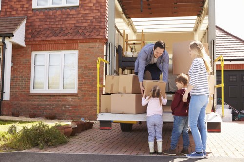 Professional movers carrying furniture through a local Swiss Cottage property